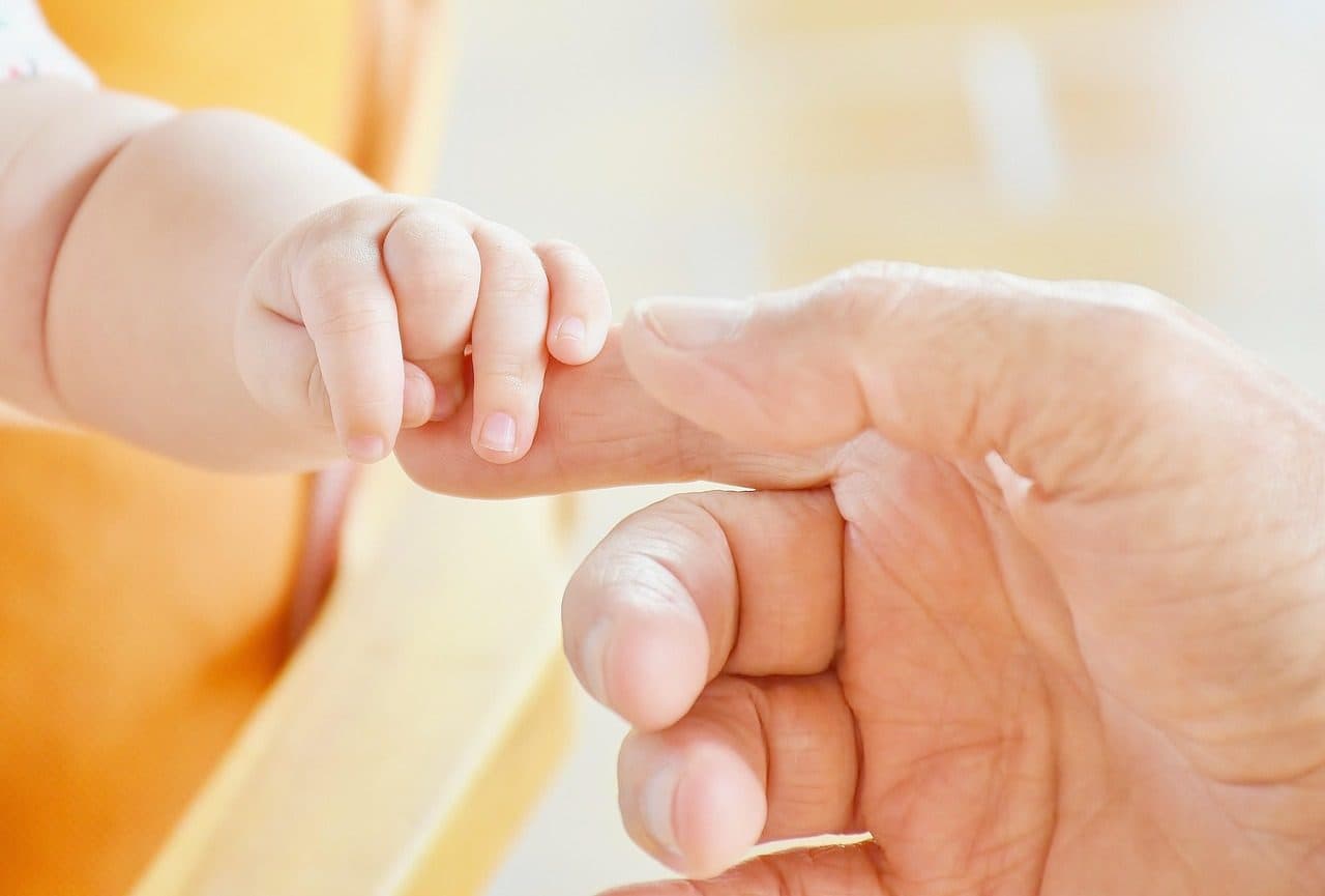 La mano de un recién nacido agarrando el dedo de un adulto